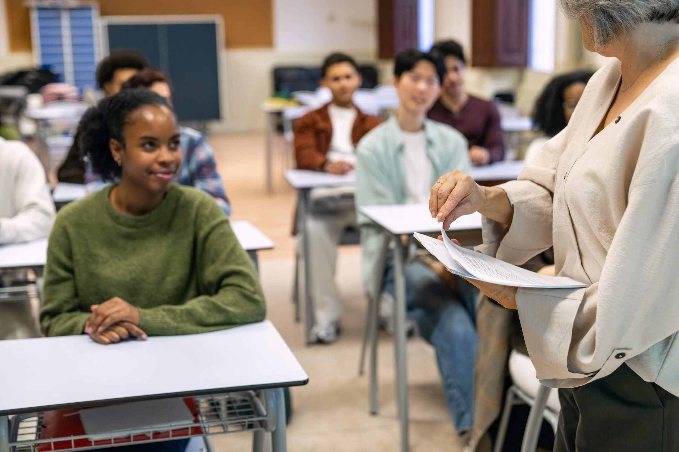 Teacher’s,Hands,Distributing,Exam,Papers,To,Students,In,A,University