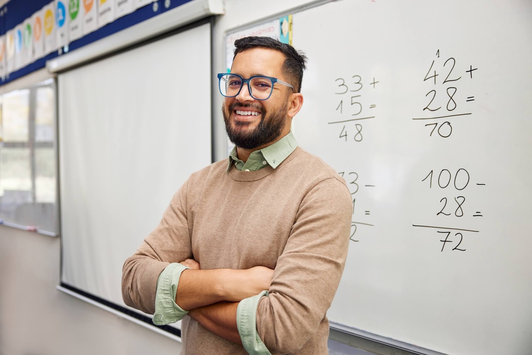 Happy,Teacher,Explaining,Mathematics,At,Whiteboard,In,Classroom.,Portrait,Of