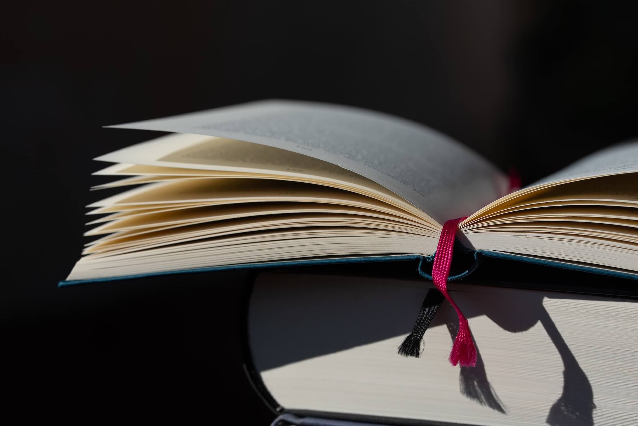 Close-up,Of,An,Open,Book,Against,A,Dark,Background.,The