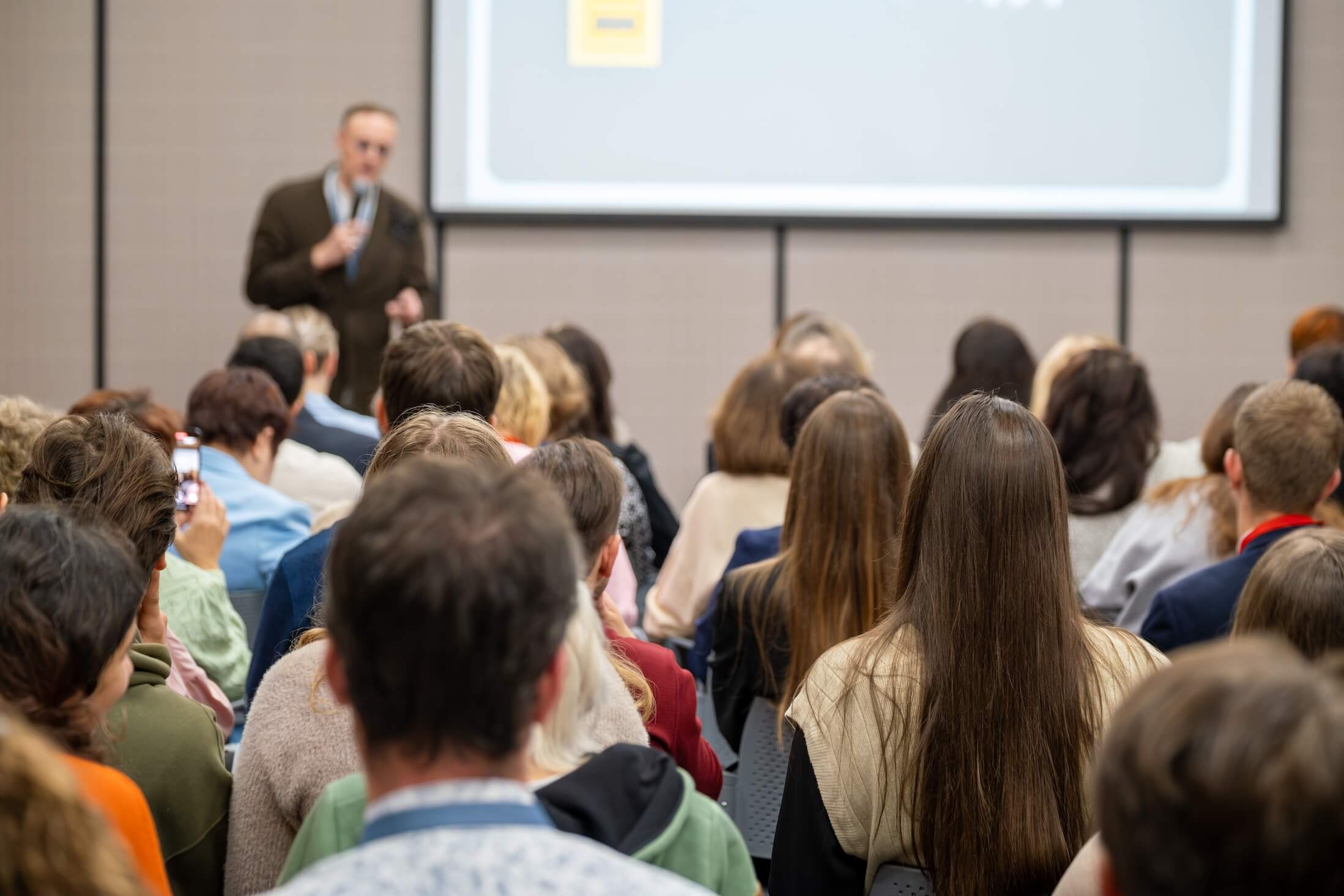 Crowd,Seated,Listening,To,Presenter,During,Business,Conference,Seminar,,Focused